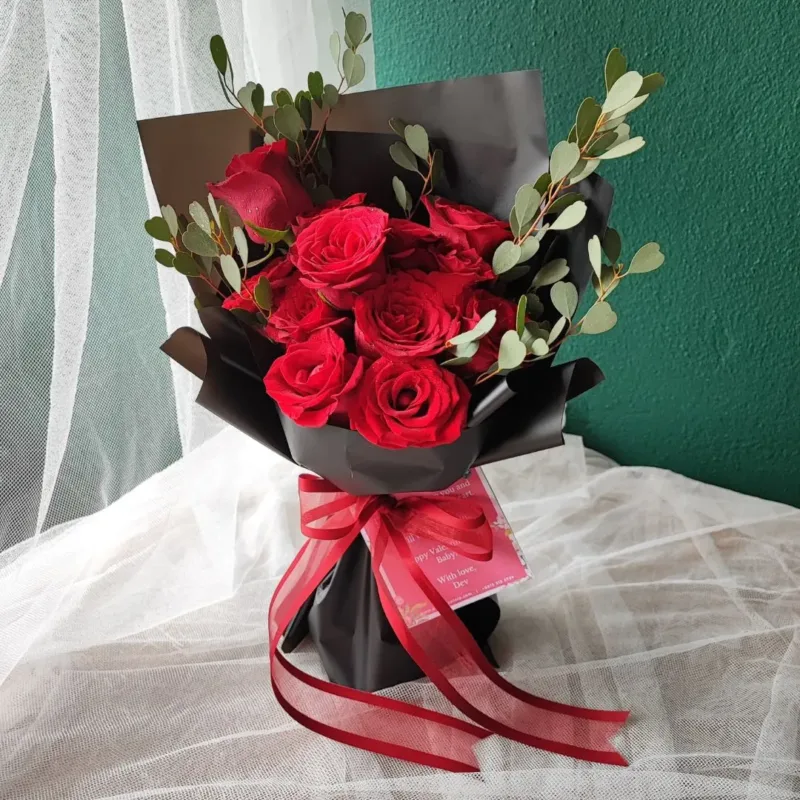 red rosed with folidage in black wrap